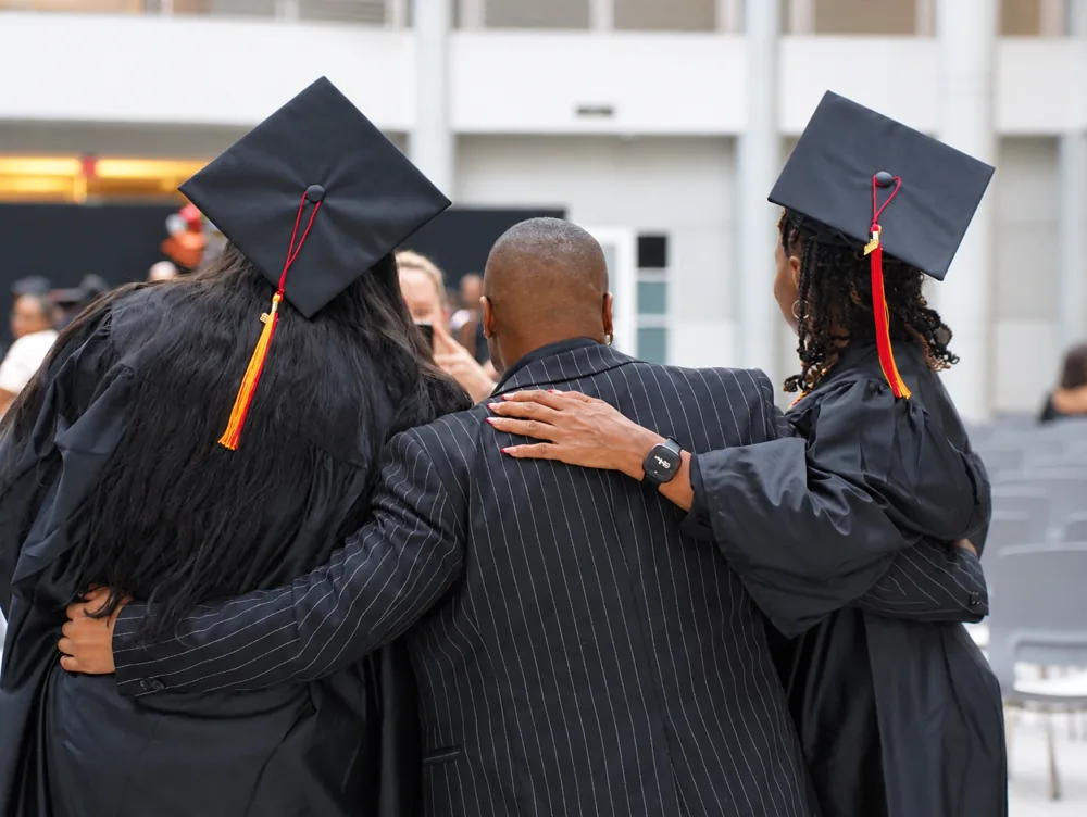 HCI graduates hugging after commencement